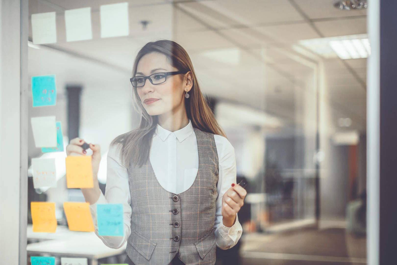 Frau mit Post-its arbeitet ein Kanban Board aus